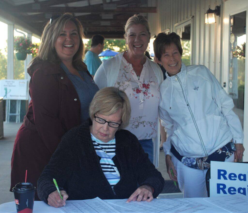 A group of 4 women smiling by the registration table